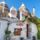 A line of white washed Trullo with conical roofs in Alberobello Puglia
