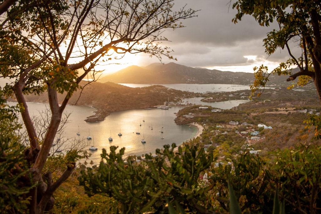 Sunset view from high up in Antigua at Shirley Heights, an old fort looking down on a harbour with boats