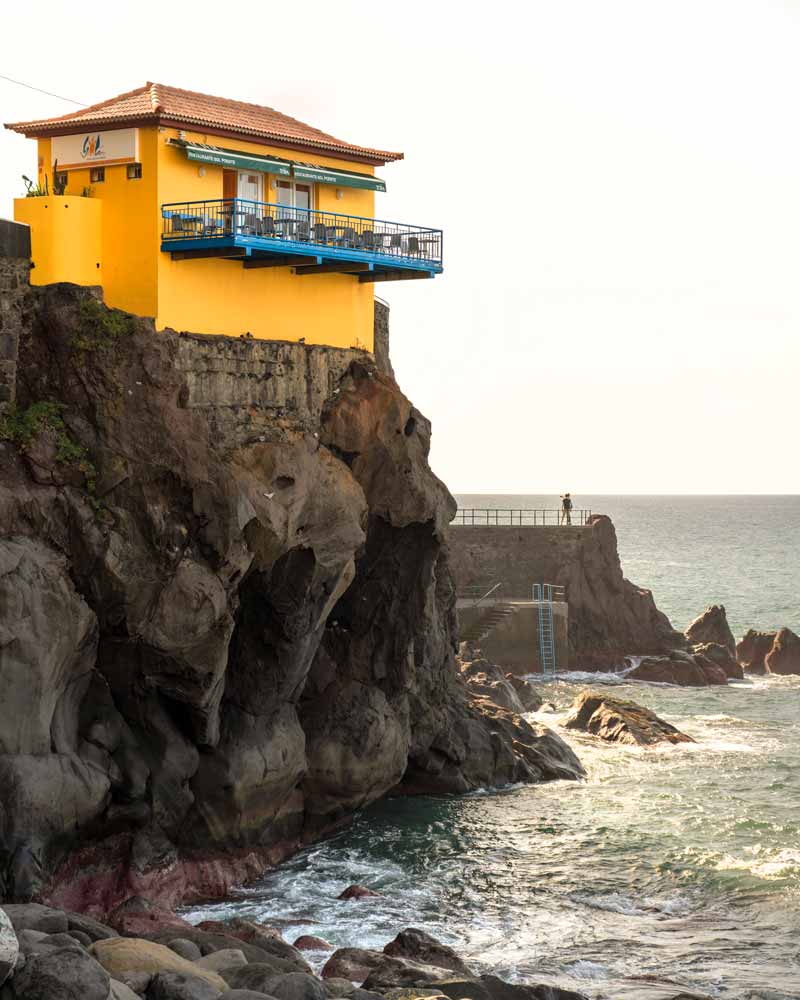 A bright yellow cafe perched on a cliff in Porto do Sol in Madeira