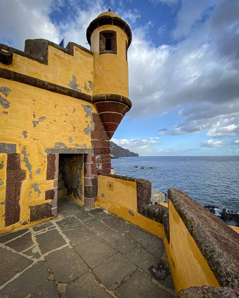 Funchal is home to many forts, and this bright yellow one with a turret sits on the oceans edge
