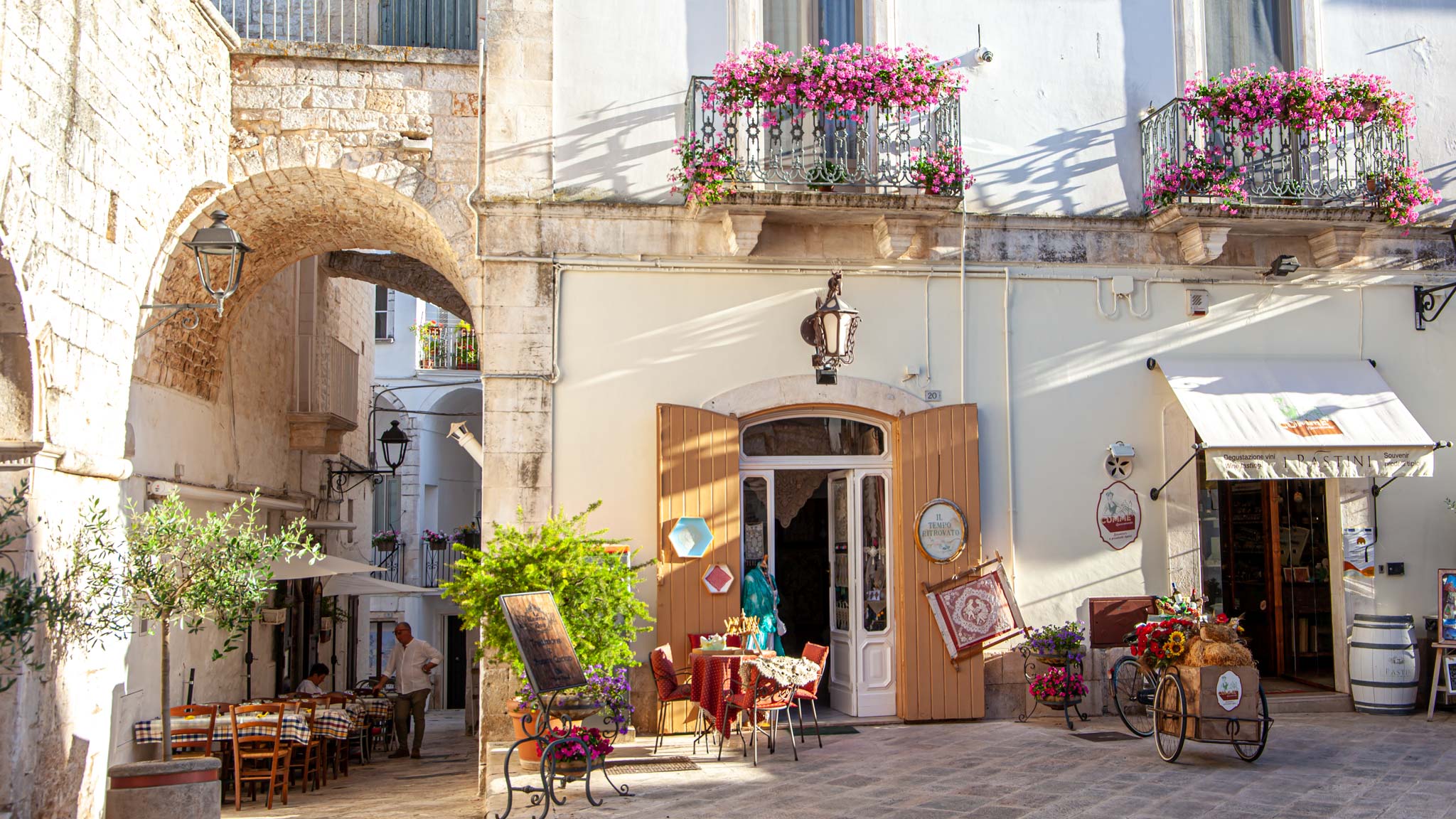 Sunset in Puglia with a golden glow over white washed shops in Locorotondo