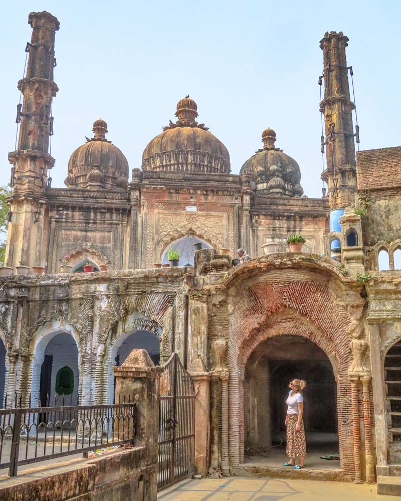 The old mosque in the Residency Lucknow with a girl standing in the archway looking up at the domed roofs