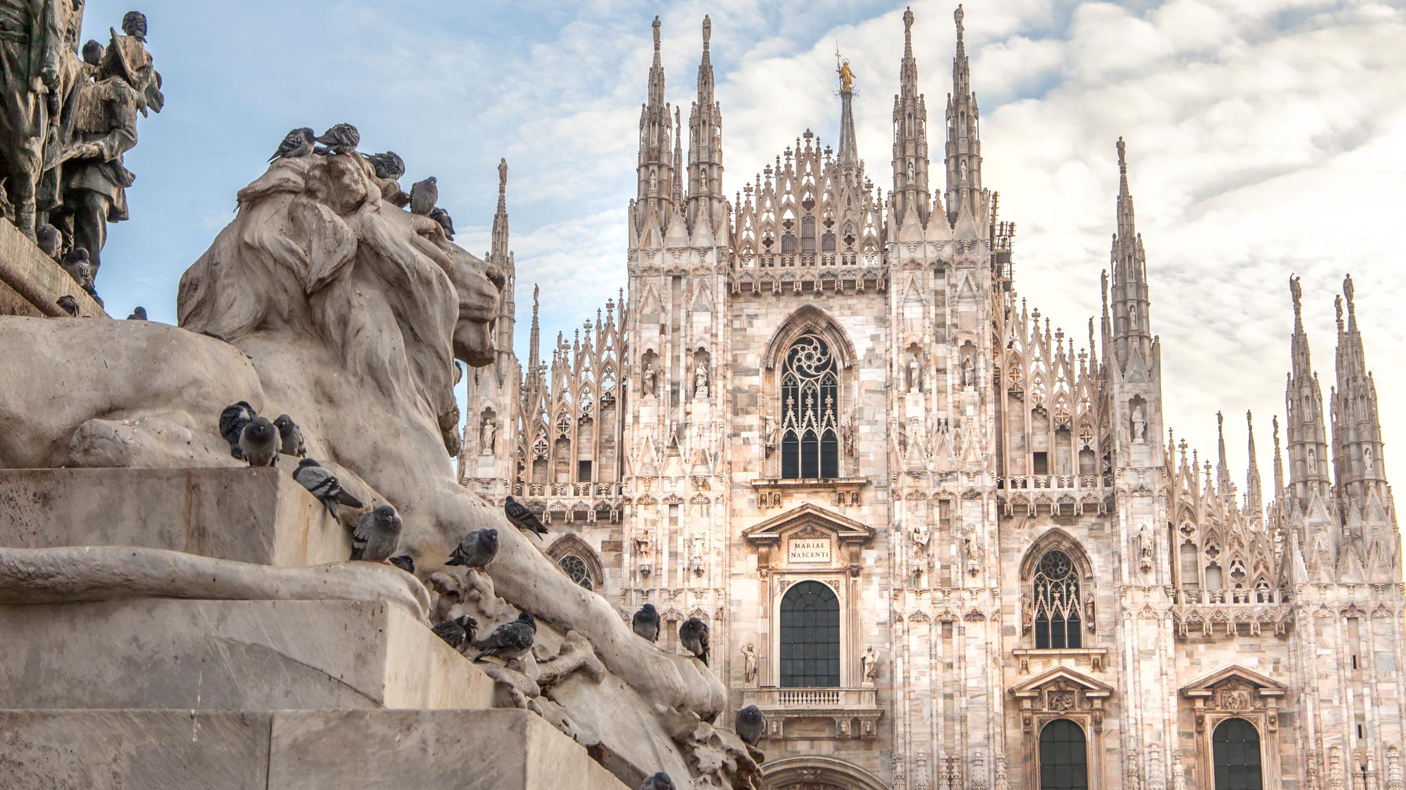 Milano Duomo with a lion statue in the foreground