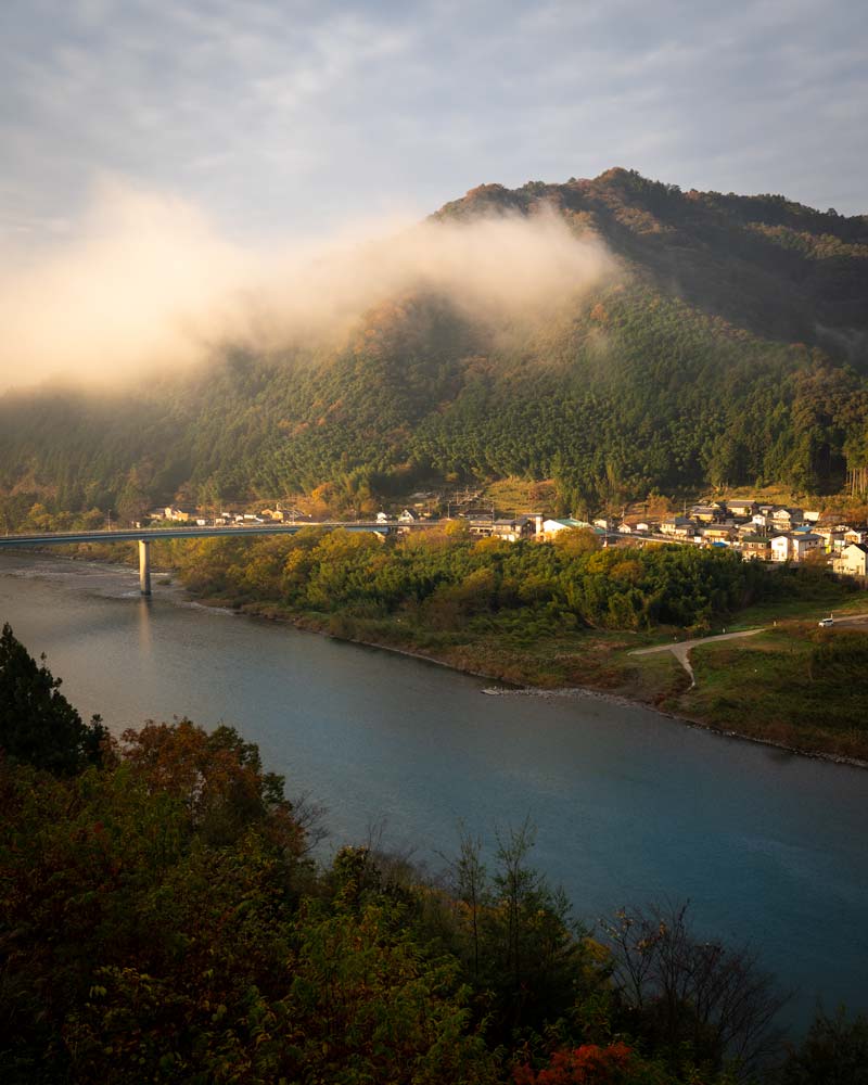 The Shimanto River at sunrise with clouds floating over the village
